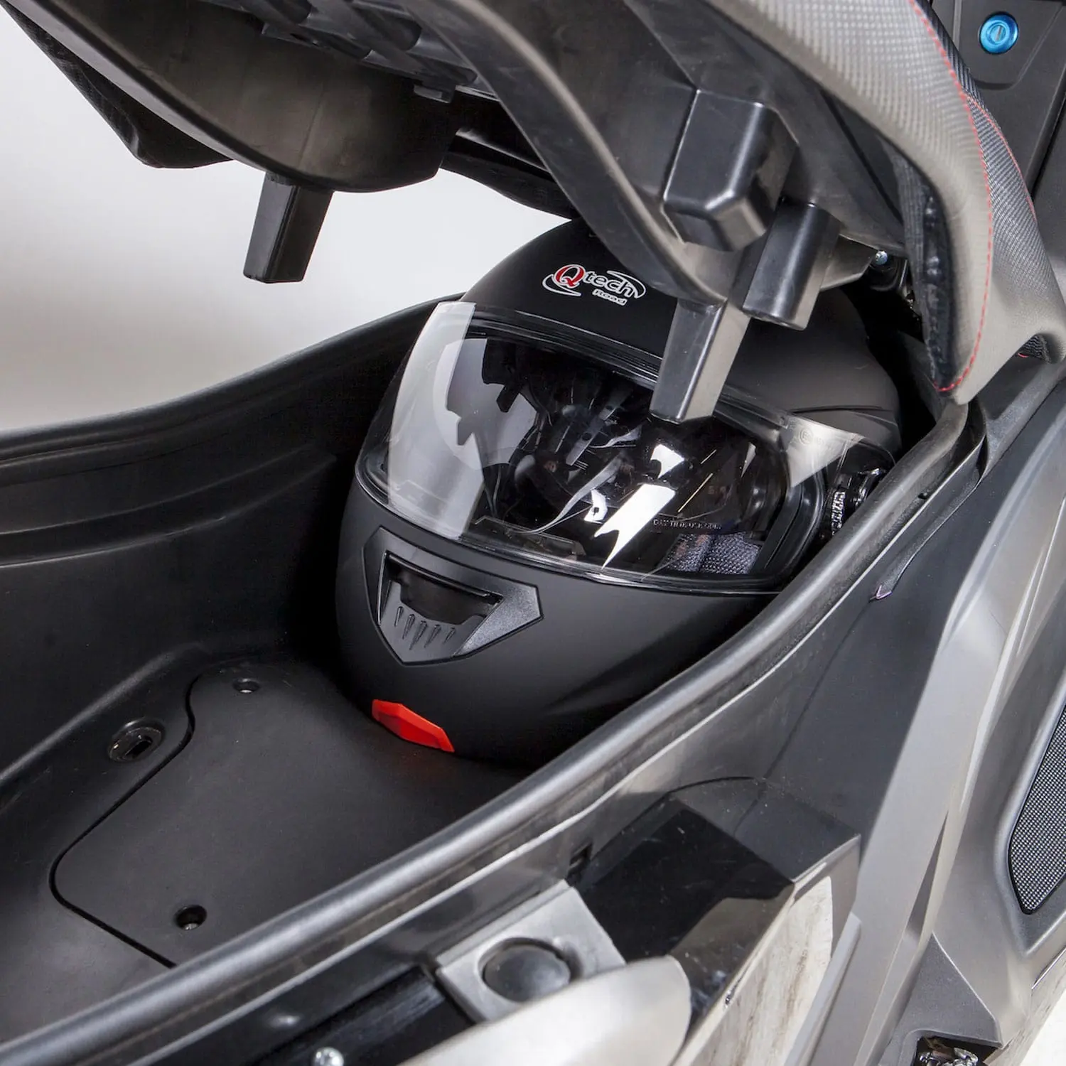 Coffre du scooter électrique Pink Mobility Pink Fly Phase 3 avec casque intégral rangé sous la selle.